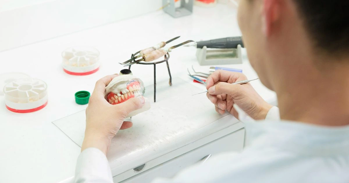 Dental technician working on a denture model, demonstrating the precision and custom craftsmanship used in making partials in Annapolis.